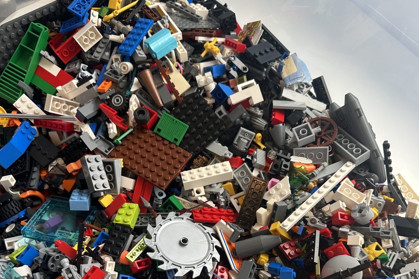 A large tub of mixed loose LEGO® bricks in many colours.
