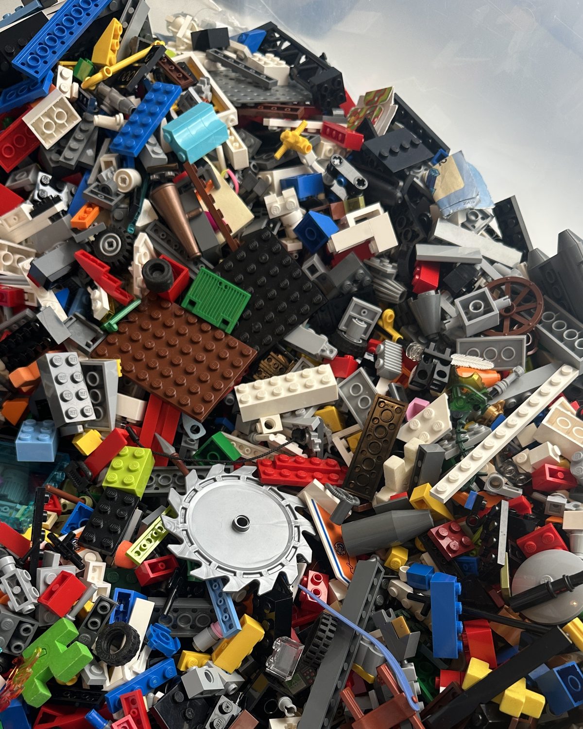 A large tub of mixed loose LEGO® bricks in many colours.